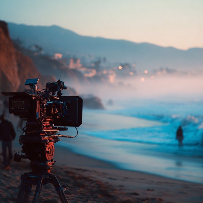 A cinema camera set up on the coast at dusk